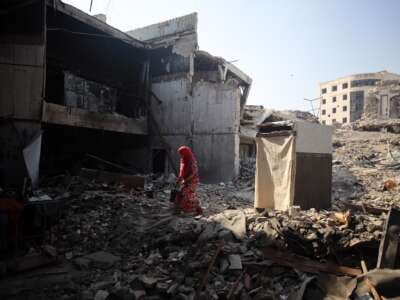 A displaced Palestinian walks inside the destroyed Rashad Al-Shawa Cultural Center, which is turned into a shelter, in Gaza City, on April 20, 2025.