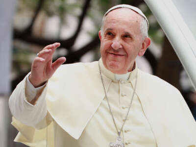 Pope Francis waves to thousands of followers as he arrives at the Manila Cathedral on January 16, 2015, in Manila, Philippines.