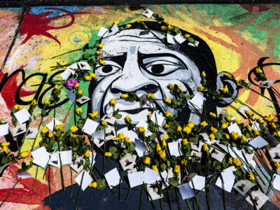 A mural of George Floyd at George Floyd Square is adorned with yellow roses and paper notes at George Floyd Square, May 23, 2025, in Minneapolis, Minnesota, during a tribute marking nearly five years since Floyd's killing by police.