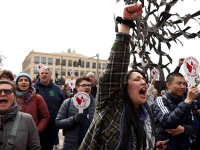 A graduate student at Northeastern University cheers as Congresswoman Ayanna Pressley (not pictured) speaks to a crowd gathered in support of Boston University graduate worker students striking for fair pay, better health care coverage and stronger benefits, in Boston, Massachusetts, on March 26, 2024.